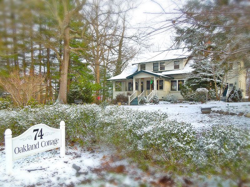 Oakland Cottage in the snow with its 74 Oakland Road sign
