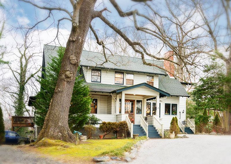 Oakland Cottage, a white craftsman bed and breakfast with green trim in Asheville, NC